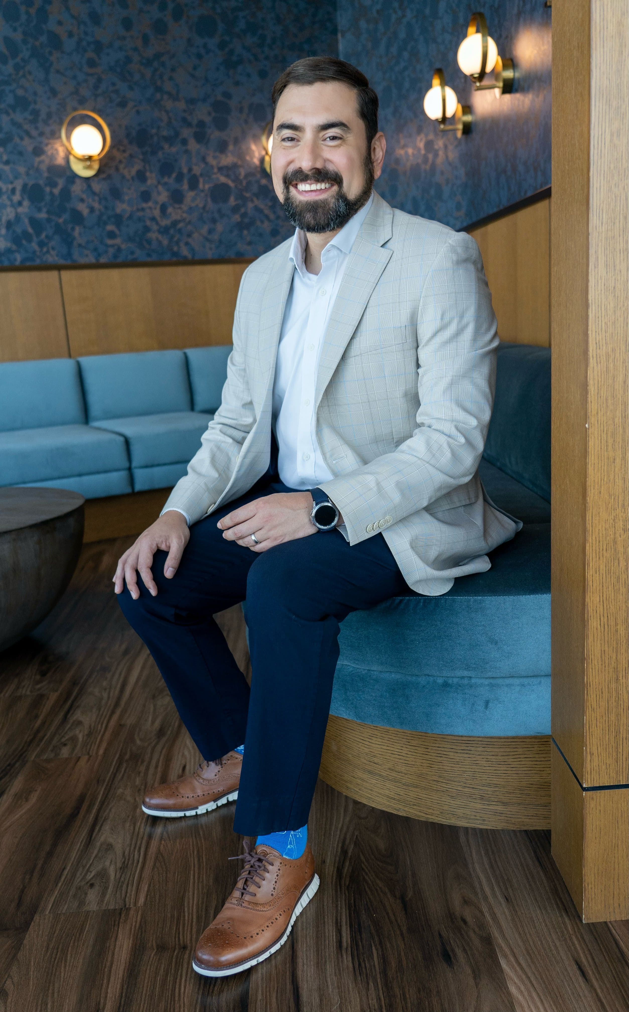 An image of Marc Hernandez, Founder of Guideline Buddy sitting on a blue couch